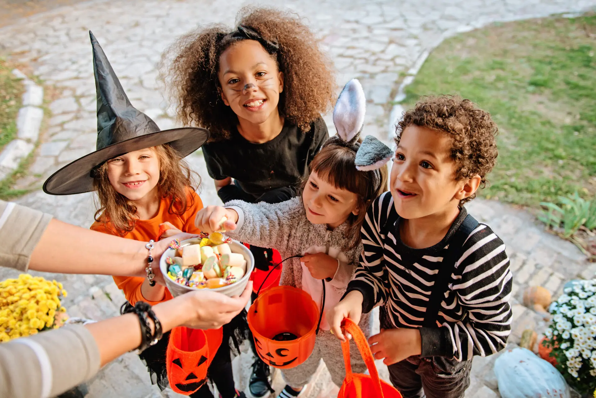 Children in Halloween costumes, trick or treating for candy.
