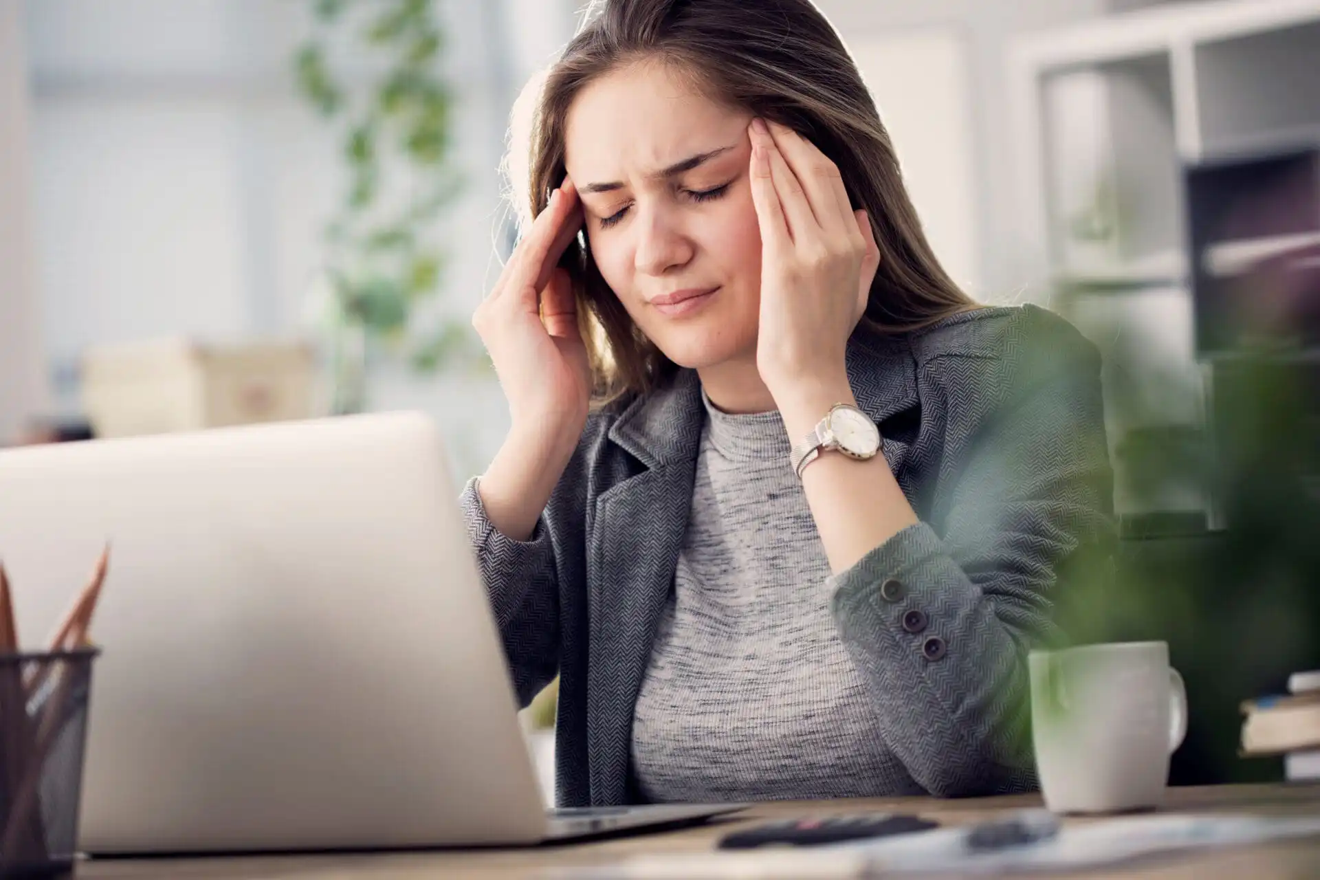 Working woman having a TMJ headache
